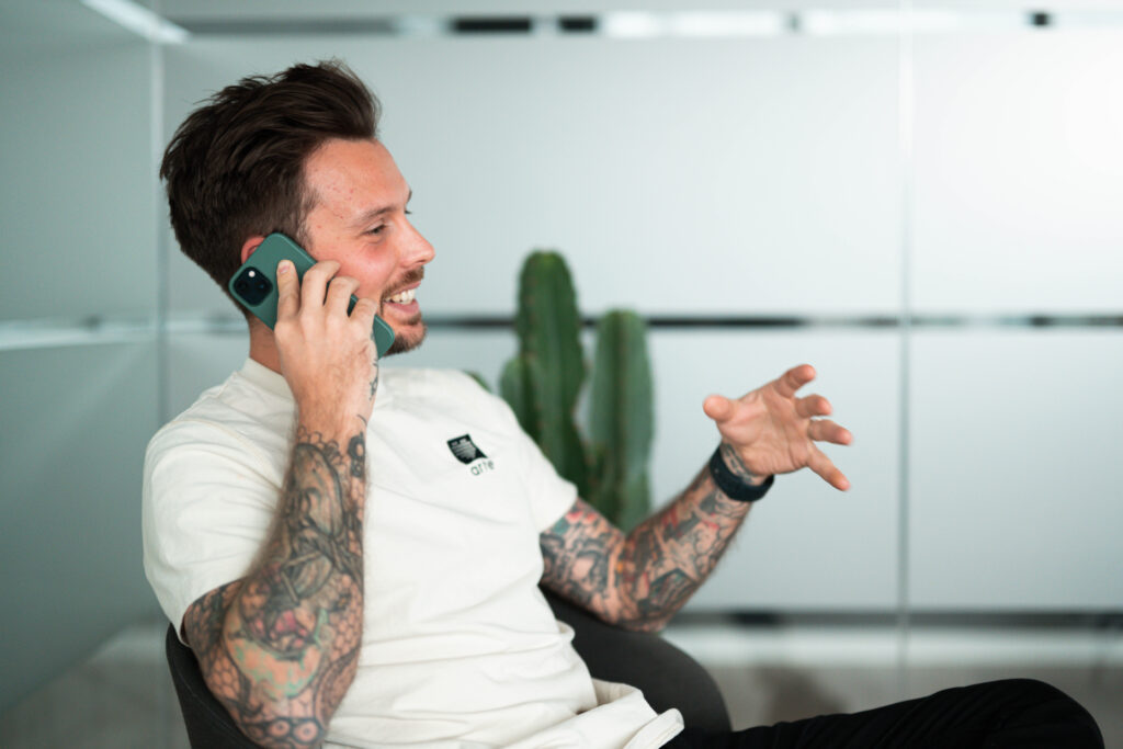 Man met tattoos aan het bellen met klant