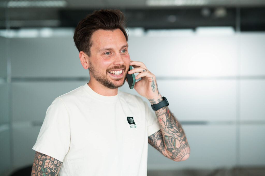 Man met tattoos belt al lachend