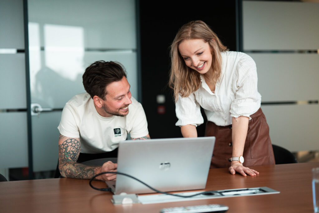 2 collega's lachen aan laptop