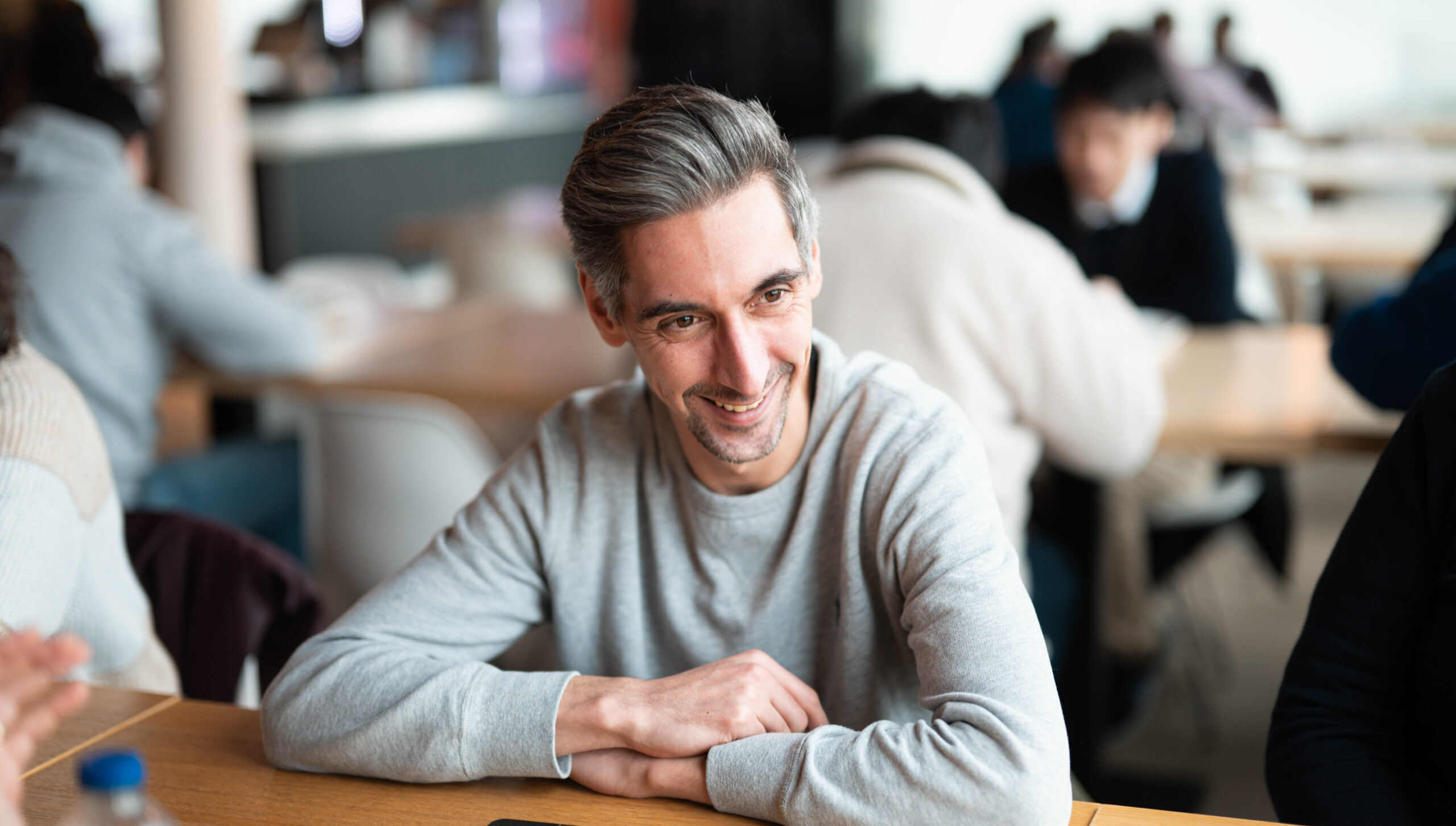 glimlachende man aan tafel